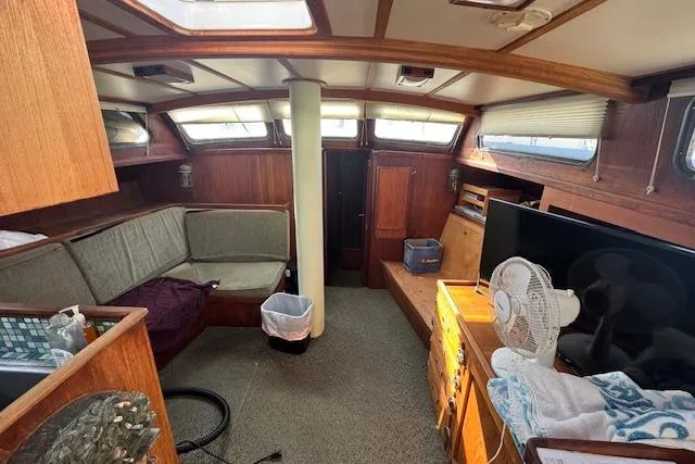 Slide: The Image of 1973 Maple Leaf Center Cockpit interior with seating, TV, and fan in cozy cabin. - 14