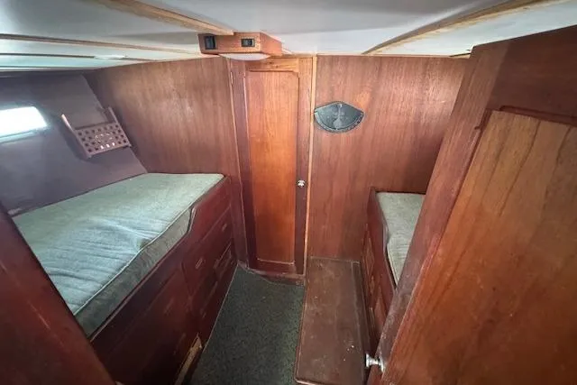 Slide: The Image of 1973 Maple Leaf Center Cockpit interior with wooden paneling and twin berths. - 15