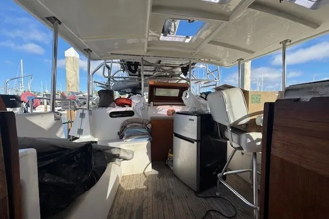 Slide: The Image of 1973 Maple Leaf Center Cockpit sailboat interior with seating, fridge, and helm under a clear sky. - 19