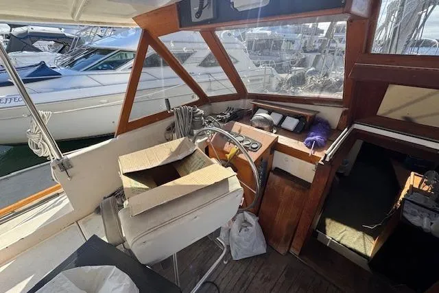 Slide: The Image of 1973 Maple Leaf Center Cockpit interior with steering wheel, controls, and marina view. - 22