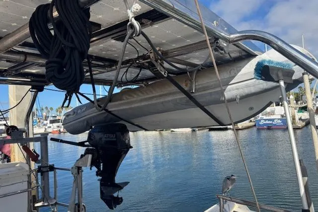 Slide: The Image of Hanging dinghy on 1973 Maple Leaf Center Cockpit sailboat with outboard motor at marina. - 31