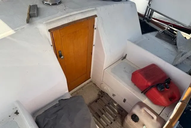 Slide: The Image of 1973 Maple Leaf Center Cockpit with wooden door and fuel containers on deck. - 33