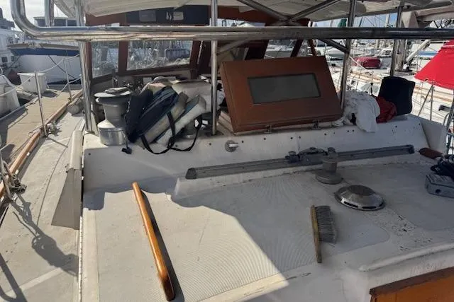 Slide: The Image of 1973 Maple Leaf Center Cockpit sailboat deck with equipment and marina background. - 34