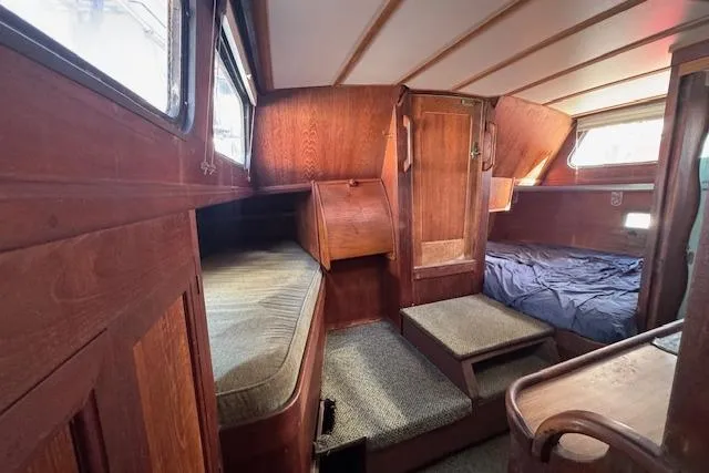 Slide: The Image of 1973 Maple Leaf Center Cockpit interior with wooden finish and cozy sleeping area. - 9