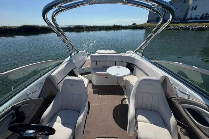 Slide: The Image of 2006 Cobalt 272 boat interior with seating and table on calm water. - 14