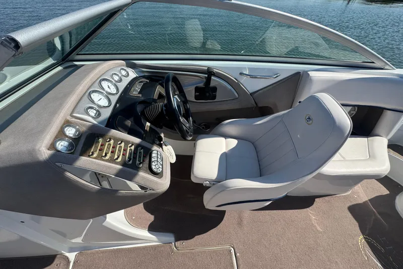 Slide: The Image of 2006 Cobalt 272 boat cockpit with steering wheel and control panel, overlooking water. - 15