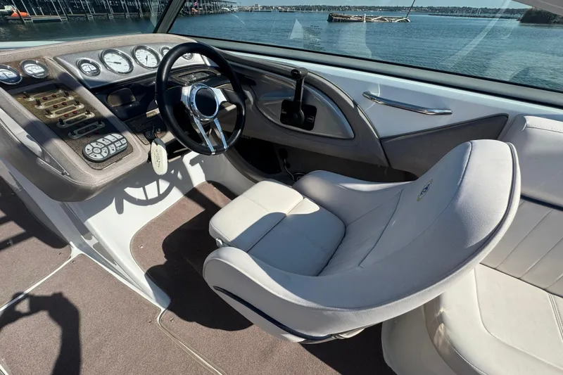 Slide: The Image of 2006 Cobalt 272 boat cockpit with steering wheel and control panel, overlooking serene waters. - 16
