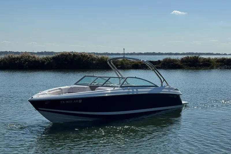 Slide: The Image of 2006 Cobalt 272 boat cruising on a calm lake under a clear blue sky. - 2