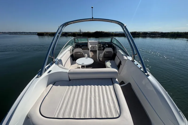 Slide: The Image of 2006 Cobalt 272 boat interior with seating and table on calm water. - 23