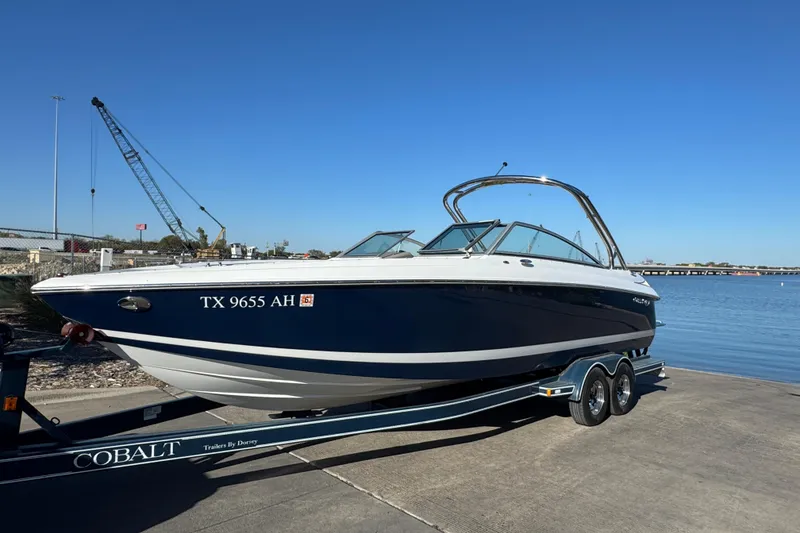 Slide: The Image of 2006 Cobalt 272 boat on trailer by waterfront, clear blue sky background. - 8