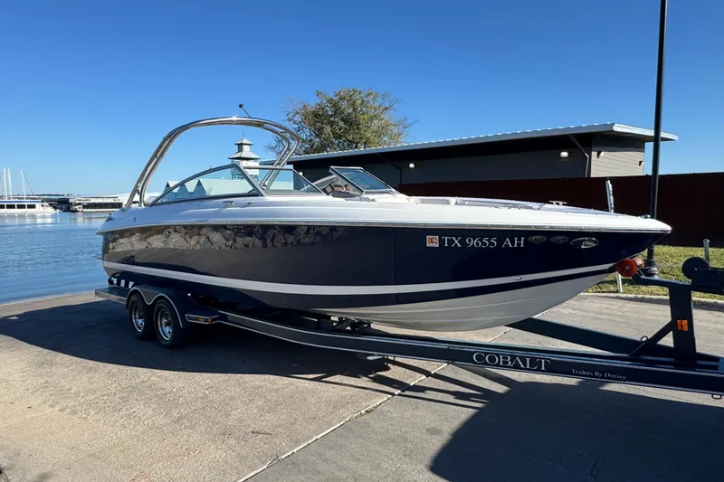 Slide: The Image of 2006 Cobalt 272 boat on trailer by waterfront, clear sky background. - 9