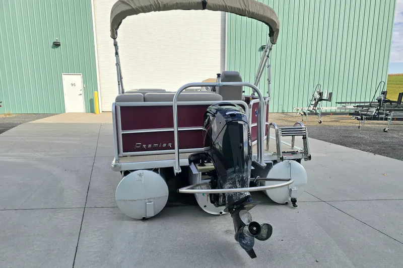 Slide: The Image of Outboard motor of 2017 Premier 220 SunSation with protective guard, showing wear and corrosion. - 3