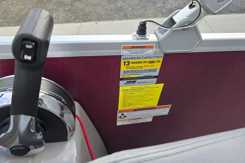 Slide: The Image of 2017 Premier 220 SunSation pontoon boat with outboard motor, parked near a teal building. - 33