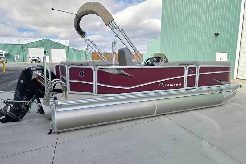 Slide: The Image of 2017 Premier 220 SunSation pontoon boat with maroon exterior, docked near green buildings. - 6