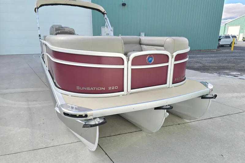 Slide: The Image of 2017 Premier 220 SunSation pontoon boat with maroon and beige design, parked outdoors. - 8