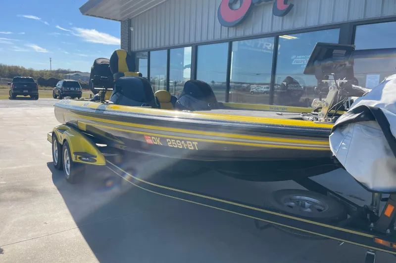 Slide: The Image of 2008 Skeeter 20i boat in yellow and black, parked outside a dealership. - 1