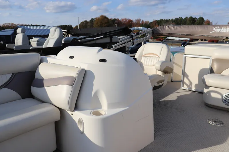 Slide: The Image of 2008 Sweetwater 2186RE boat interior with plush seating and helm, under a clear sky. - 4