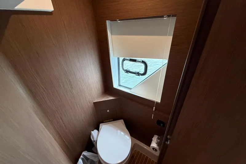 Slide: The Image of 2018 Beneteau Gran Turismo 50 yacht bathroom with wooden interior and window. - 53