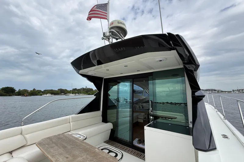 Slide: The Image of 2018 Beneteau Gran Turismo 50 yacht with American flag, docked on a cloudy day. - 64