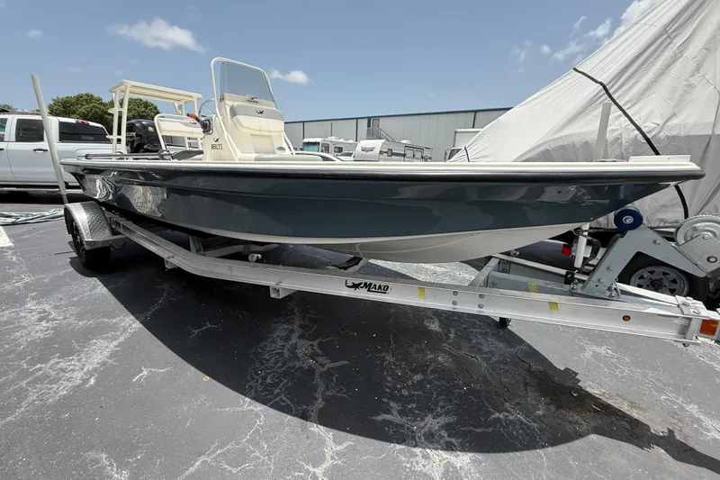 Slide: The Image of 2023 Mako 18 LTS boat on trailer, parked outdoors under clear sky. - 0