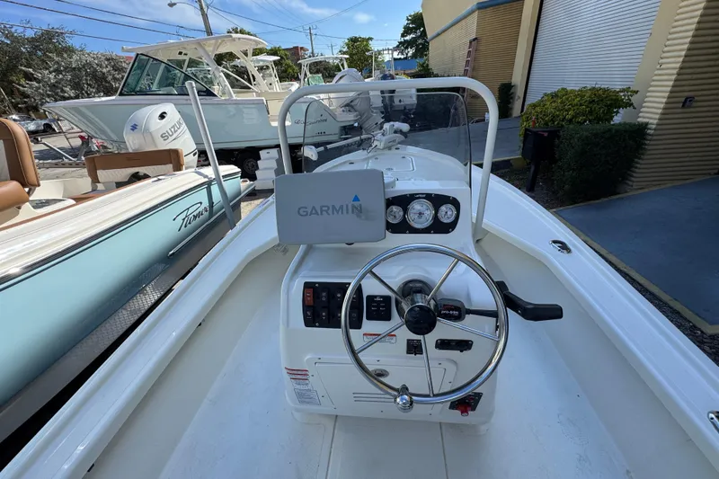 Slide: The Image of 2023 Mako 18 LTS boat interior with Garmin navigation system and steering wheel. - 12