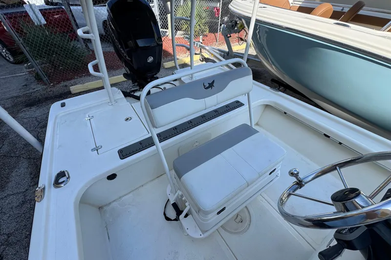 Slide: The Image of 2023 Mako 18 LTS boat interior with steering wheel and seating area. - 13