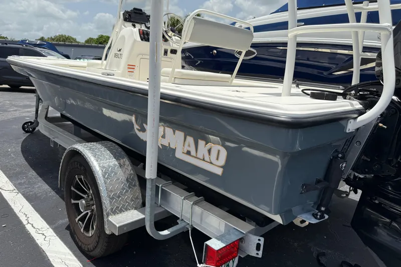 Slide: The Image of 2023 Mako 18 LTS boat on trailer, gray hull, parked outdoors. - 2