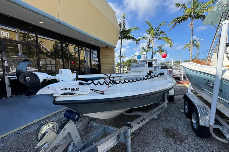 Slide: The Image of 2023 Mako 18 LTS boat with Minn Kota motor displayed outdoors near palm trees. - 3