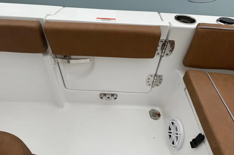 Slide: The Image of 2026 Sea Hunt Ultra 245 SE boat interior with brown cushioned seating and storage compartment. - 13