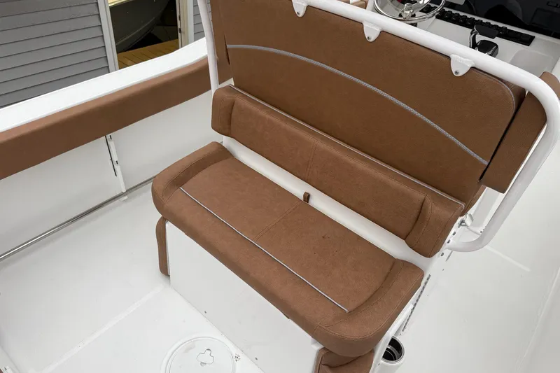 Slide: The Image of 2026 Sea Hunt Ultra 245 SE boat with brown cushioned seating and white interior. - 14