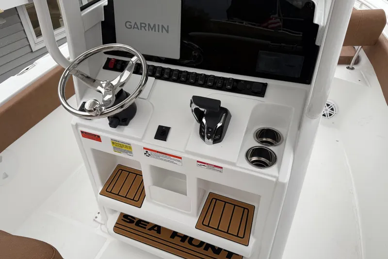 Slide: The Image of 2026 Sea Hunt Ultra 245 SE boat console with Garmin display and steering wheel. - 18