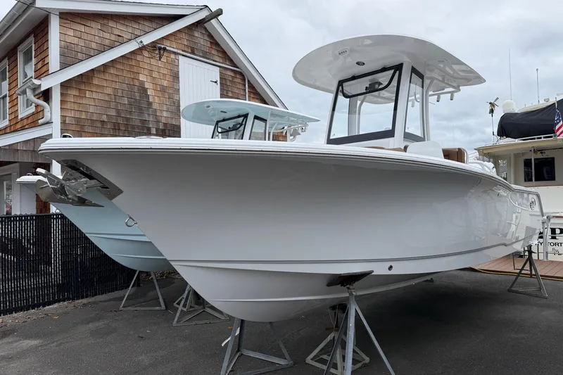 Slide: The Image of 2026 Sea Hunt Ultra 245 SE boat displayed outdoors on stands. - 5