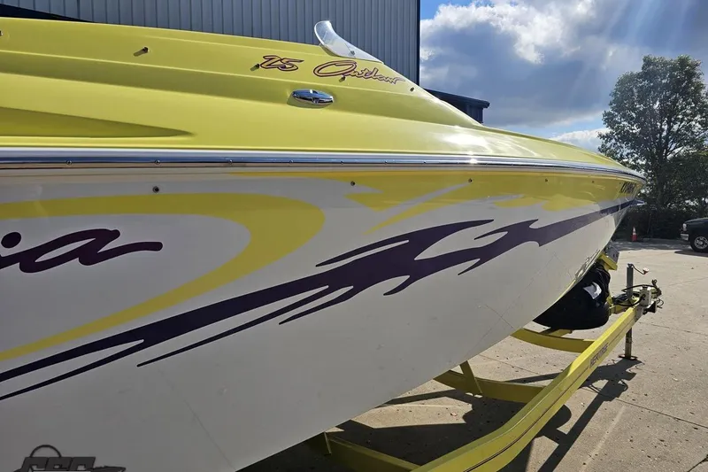 Slide: The Image of Yellow 2005 Baja 25 Outlaw boat with bold graphics on a trailer. - 10