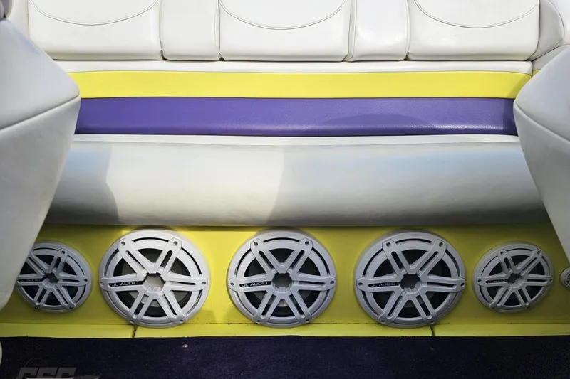 Slide: The Image of 2005 Baja 25 Outlaw boat interior with colorful seating and multiple JL Audio speakers. - 100