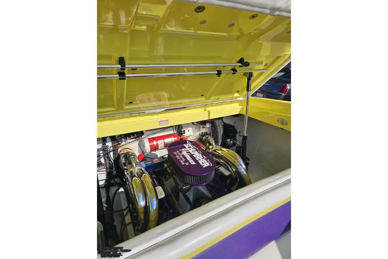 Slide: The Image of 2005 Baja 25 Outlaw boat engine compartment with vibrant yellow and purple accents. - 108