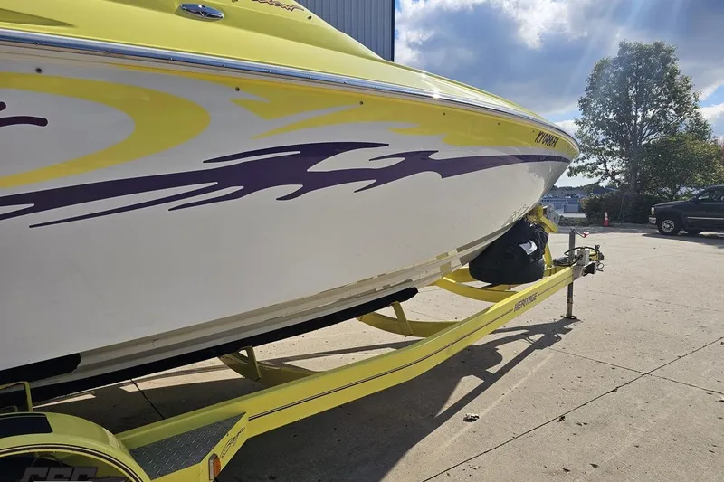 Slide: The Image of 2005 Baja 25 Outlaw boat on trailer with vibrant yellow and purple design. - 15