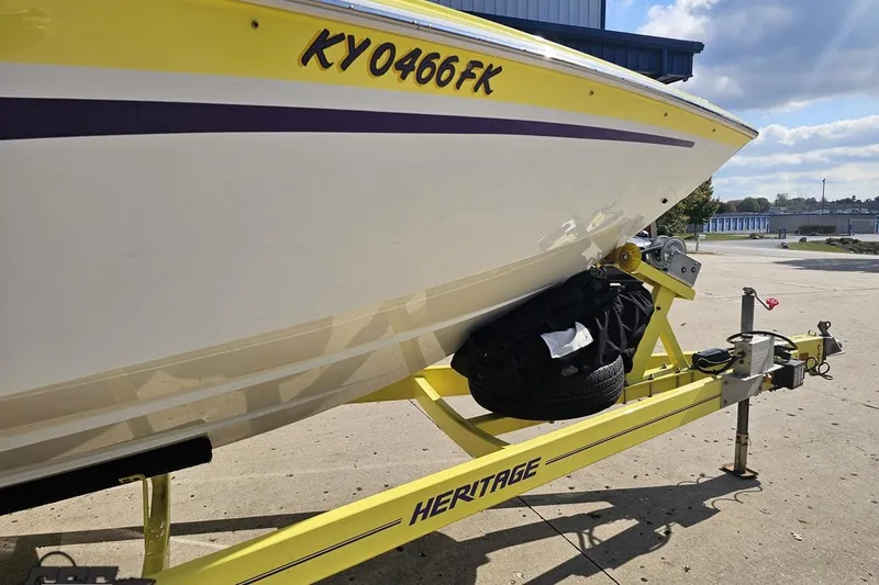 Slide: The Image of 2005 Baja 25 Outlaw boat on yellow Heritage trailer, parked outdoors. - 16