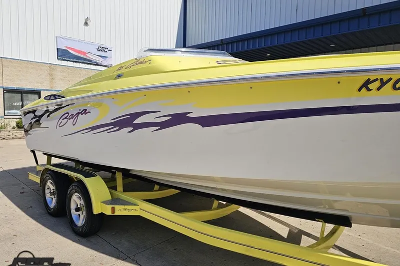 Slide: The Image of 2005 Baja 25 Outlaw boat with yellow and purple design on trailer. - 17