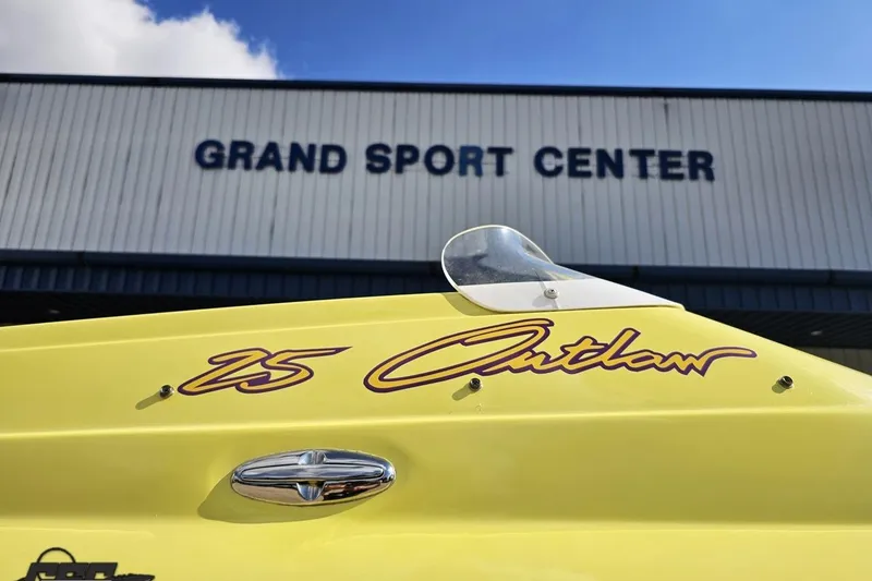 Slide: The Image of Yellow 2005 Baja 25 Outlaw boat at Grand Sport Center under blue sky. - 19