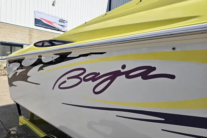 Slide: The Image of 2005 Baja 25 Outlaw boat with vibrant yellow and purple graphics. - 20