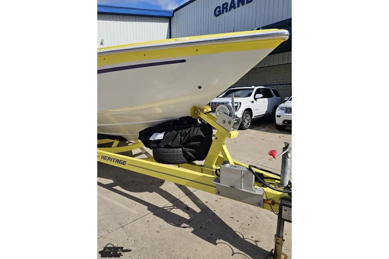 Slide: The Image of 2005 Baja 25 Outlaw boat on yellow Heritage trailer, parked outdoors. - 24
