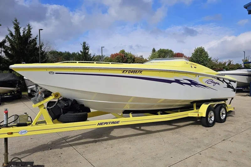 Slide: The Image of 2005 Baja 25 Outlaw speedboat on yellow trailer, parked outdoors under cloudy sky. - 29