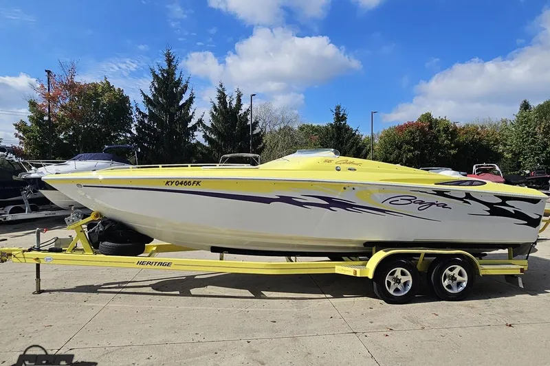 Slide: The Image of 2005 Baja 25 Outlaw speedboat on trailer, vibrant yellow and white design, parked outdoors. - 31