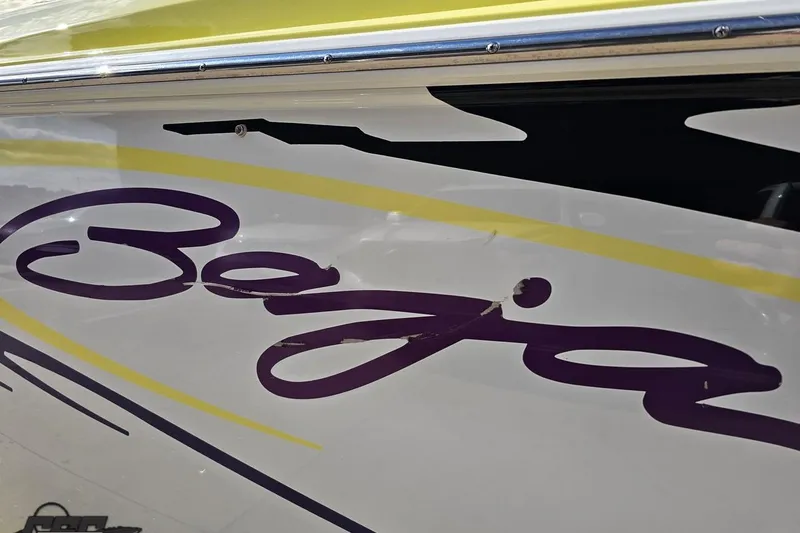 Slide: The Image of 2005 Baja 25 Outlaw boat with purple and yellow graphics on the side. - 37