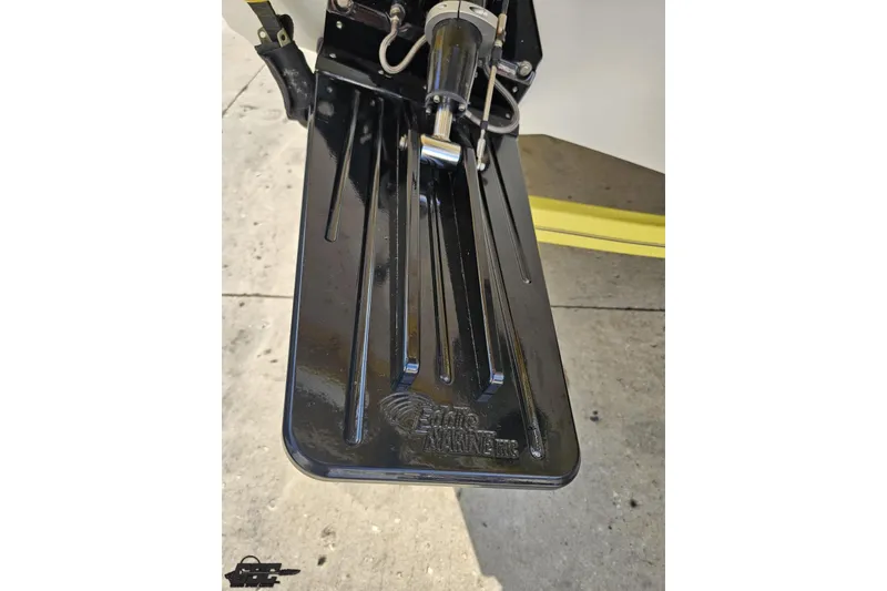 Slide: The Image of Trim tab of a 2005 Baja 25 Outlaw boat, featuring black metal finish. - 47