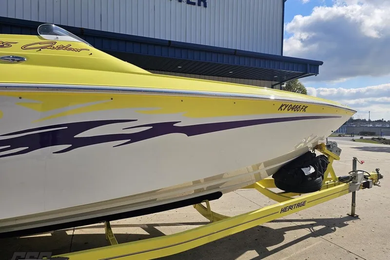 Slide: The Image of 2005 Baja 25 Outlaw boat with yellow and purple design on a trailer. - 5