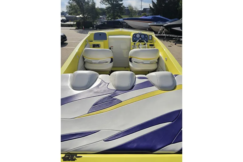 Slide: The Image of 2005 Baja 25 Outlaw boat interior with vibrant yellow and purple seating design. - 55