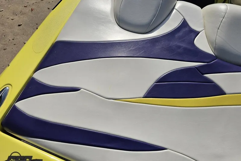 Slide: The Image of 2005 Baja 25 Outlaw boat seat with yellow, white, and purple upholstery design. - 56