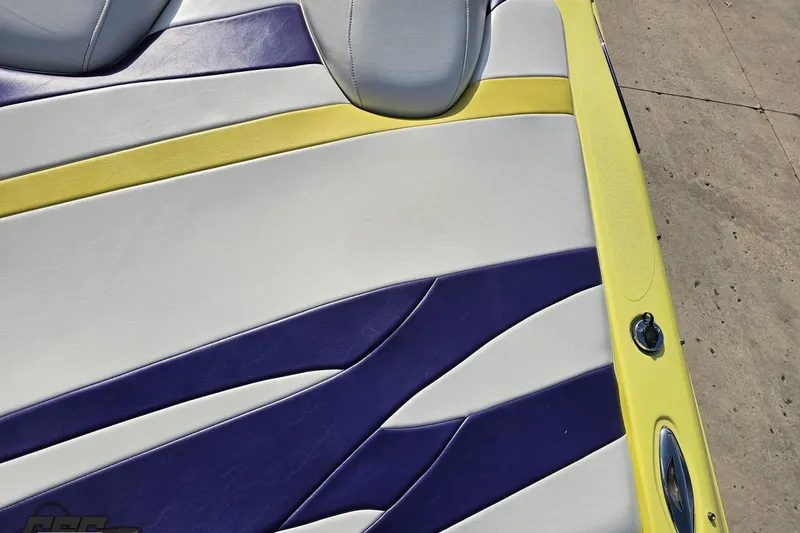 Slide: The Image of 2005 Baja 25 Outlaw boat seat with yellow, white, and purple upholstery design. - 58