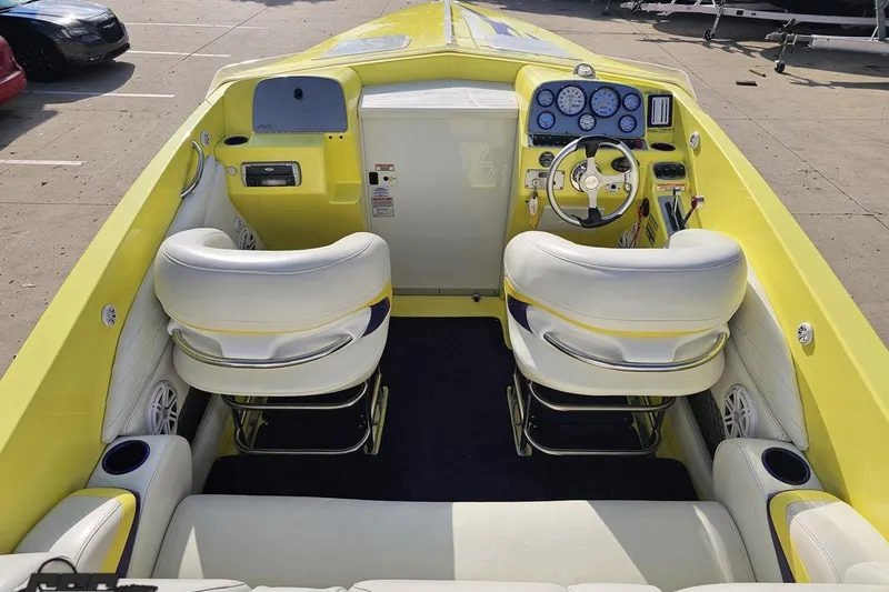 Slide: The Image of 2005 Baja 25 Outlaw boat interior with yellow and white seating, dashboard, and steering wheel. - 60